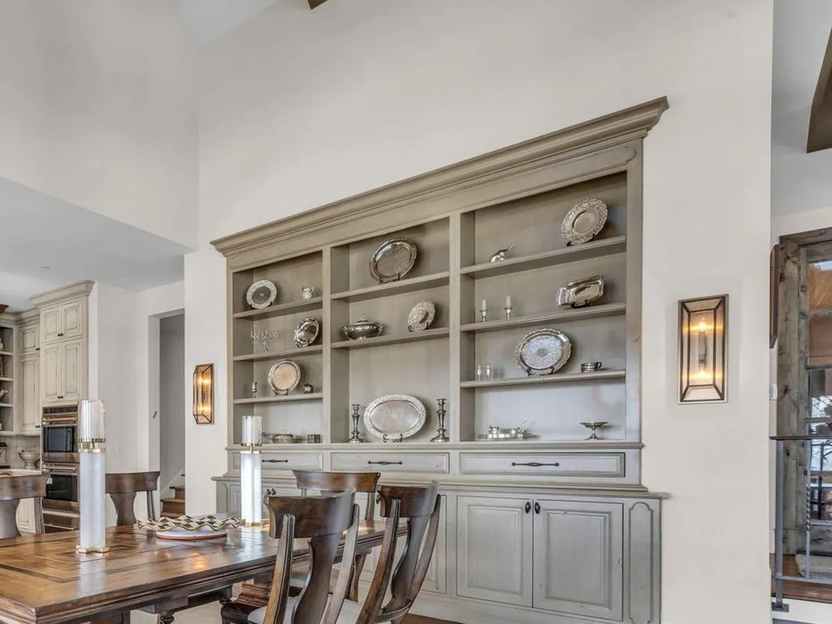 Dining room after: the built-in painted a soft greige and styled with silver pieces