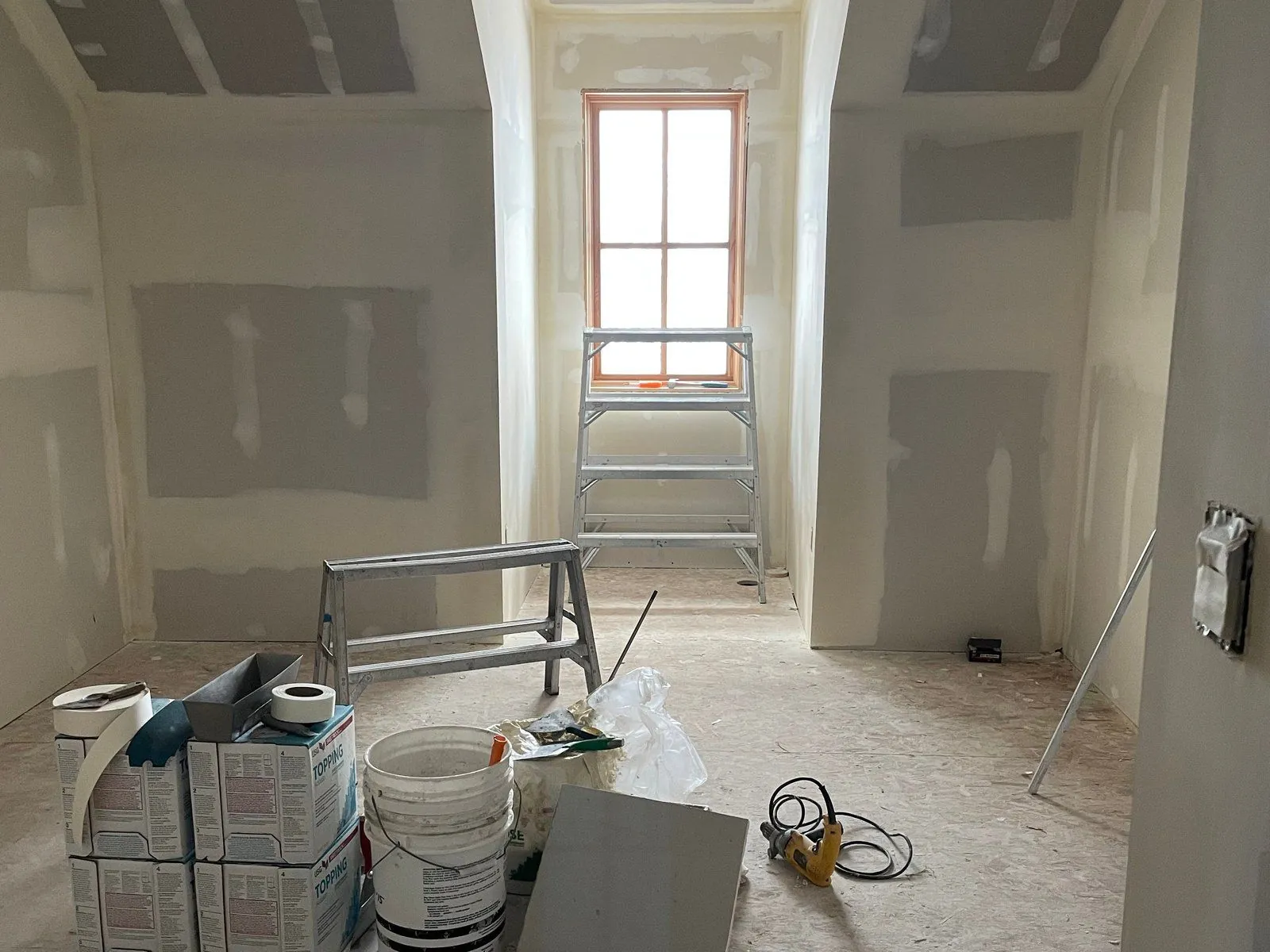 A room after drywall with a tall window