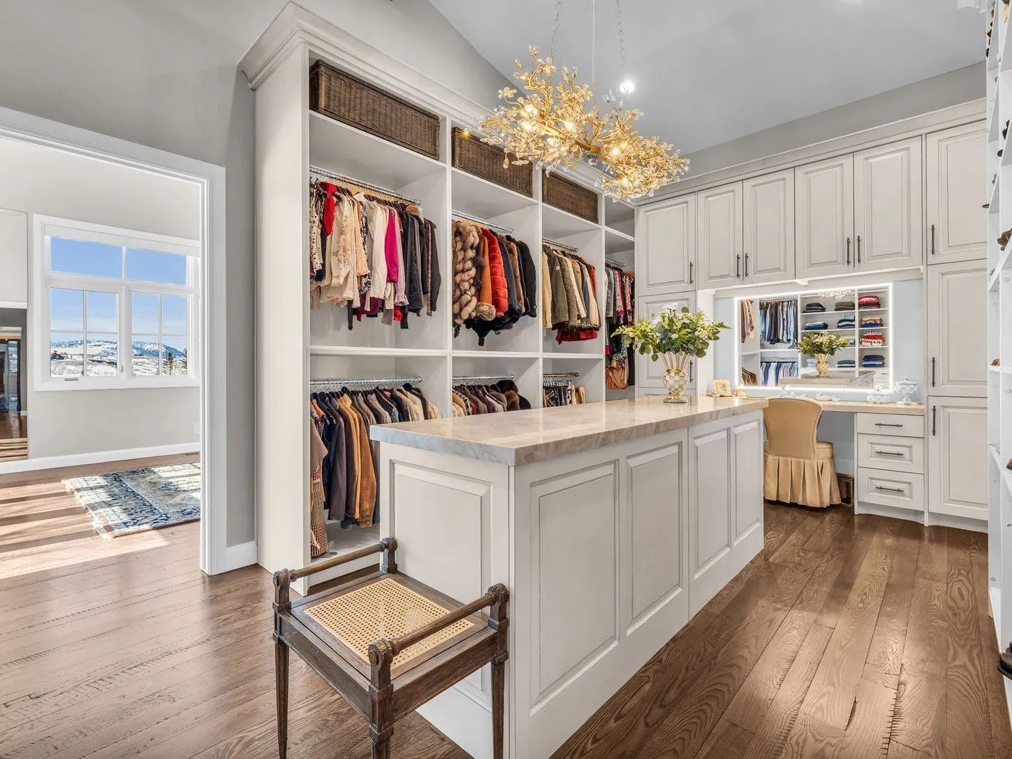 A finished room with custom cabinetry, an island and chandeliers