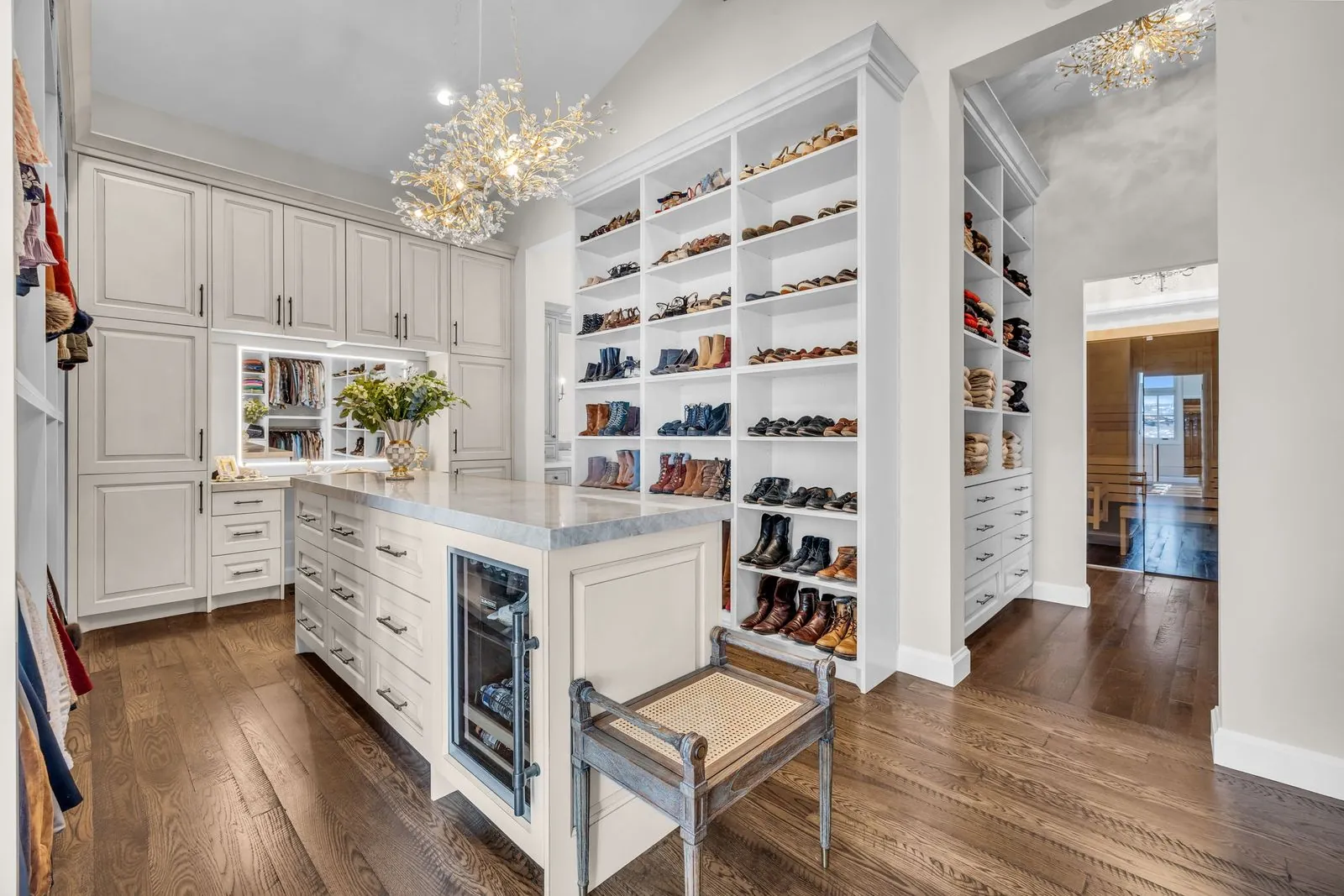 Custom dressing room with open shoe shelving and a bench