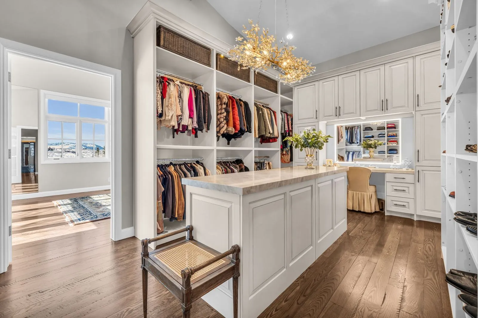 Dressing room with an island, open shelving and chandeliers