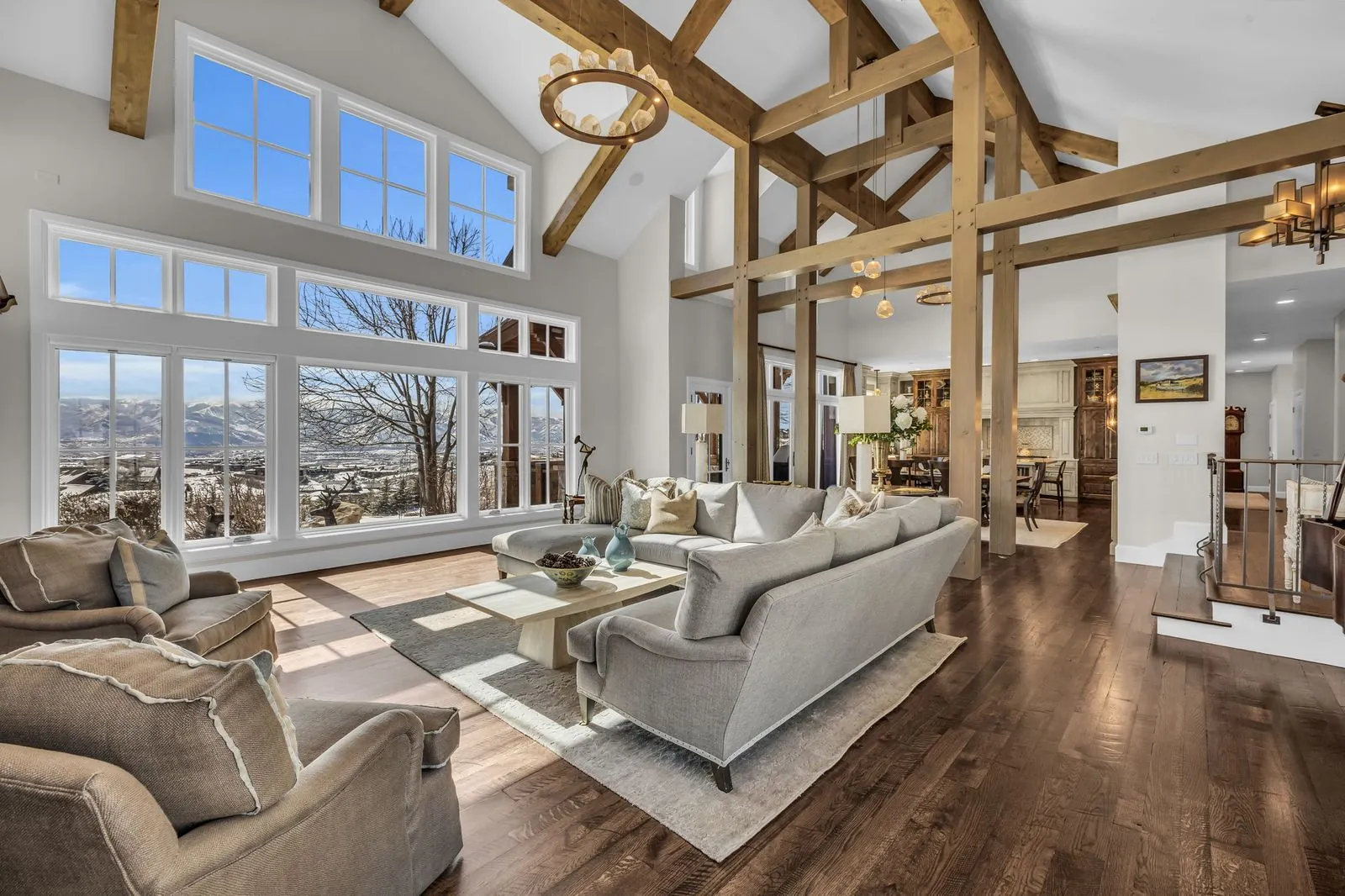 Great room with a wall of windows, timber beams and soft seating