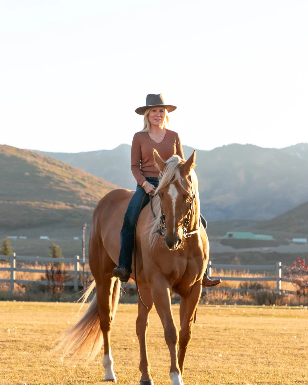 Natalie Siegel on horseback with mountains behind her